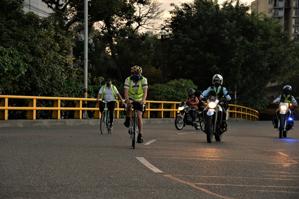 Ciclistas y motos de transito en la vía