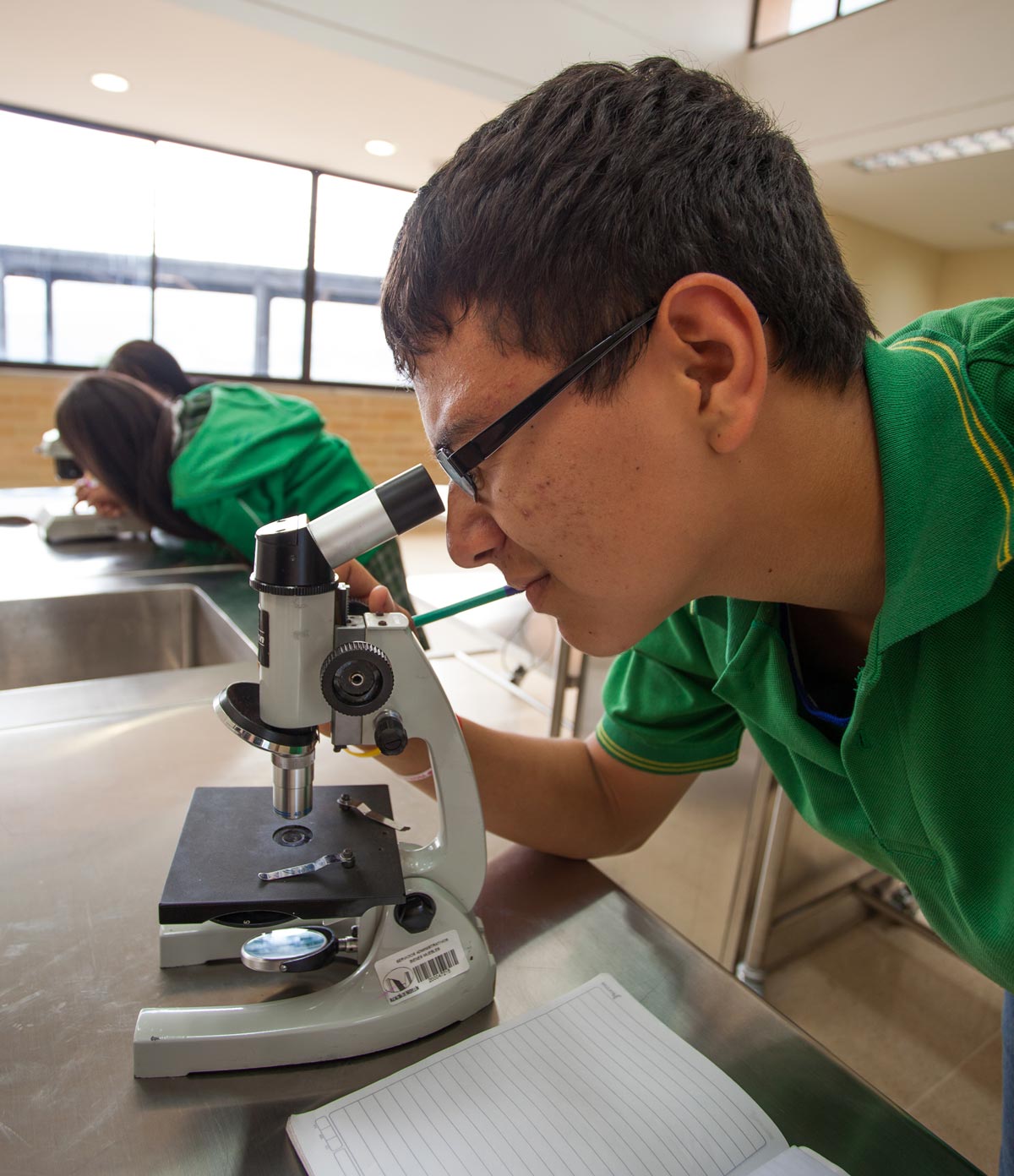 Estudiante usando microscopio