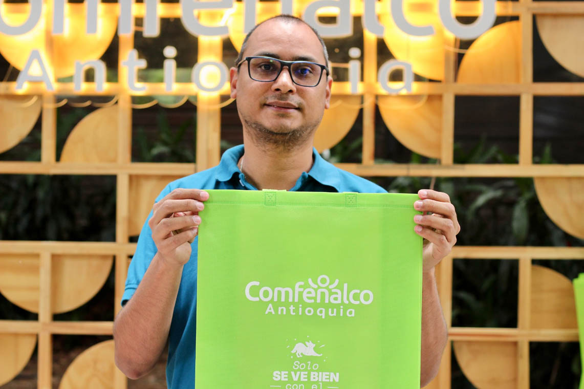Imagen de funcionario de Comfenalco con bolsa de la caja de compensación