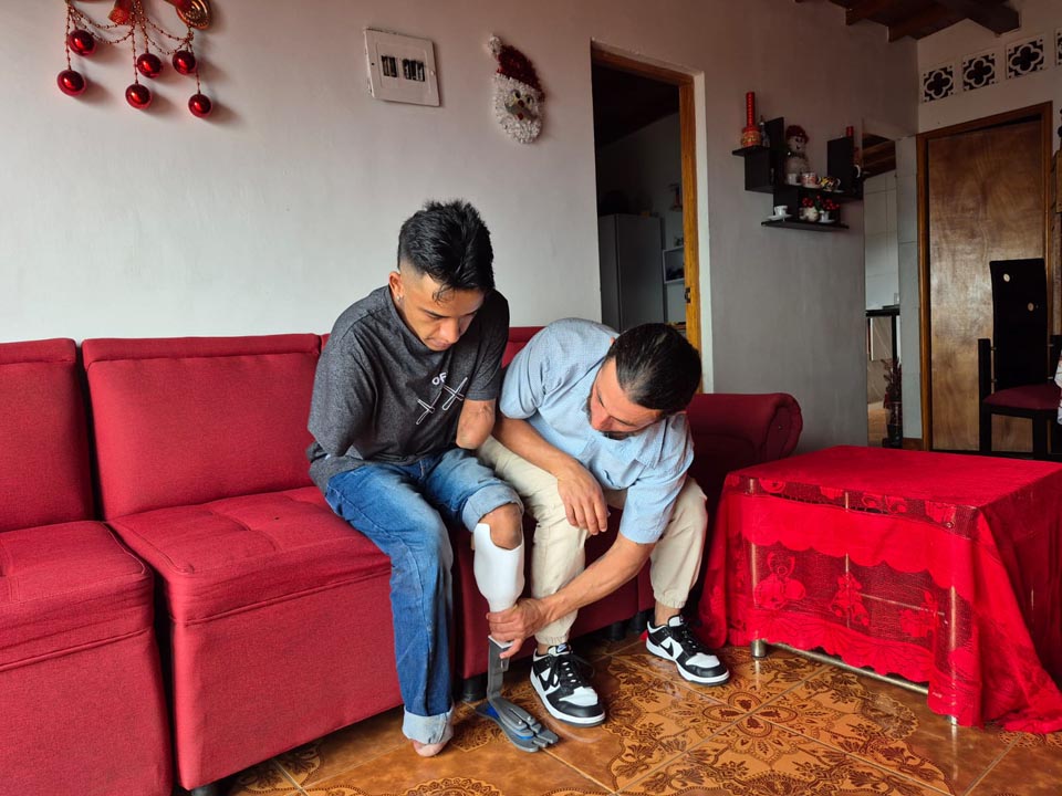 John Mesa le pone a Luis Taborda la prótesis en su pierna izquierda. Imagen prótesis creada en Medellín por egresados del ITM PONIÉNDOSELA