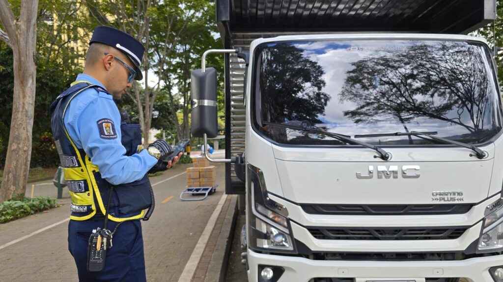 Agente de tránsito revisando camión Imagen Servir a Medellín desde la calle 1