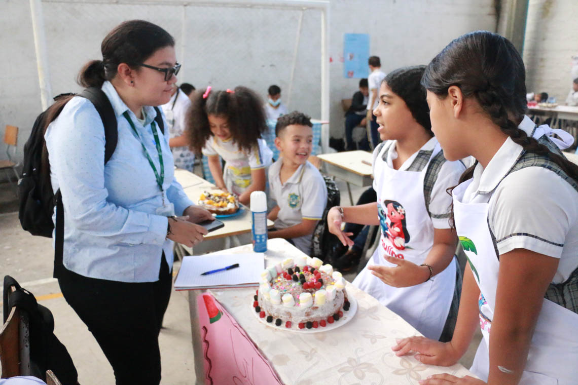 Imagen de jueza con equipo de niñas participantes en concurso Con una pizca de matemática