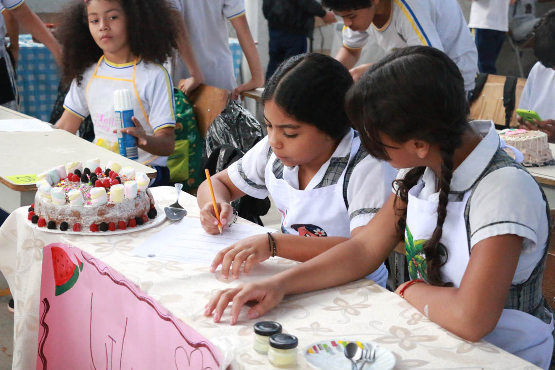Imagen de pareja de niñas resolviendo puebas en concurso Con una pizca de matemática