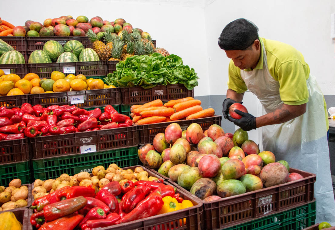 Imagen de vendedor organizando frutas y verduras