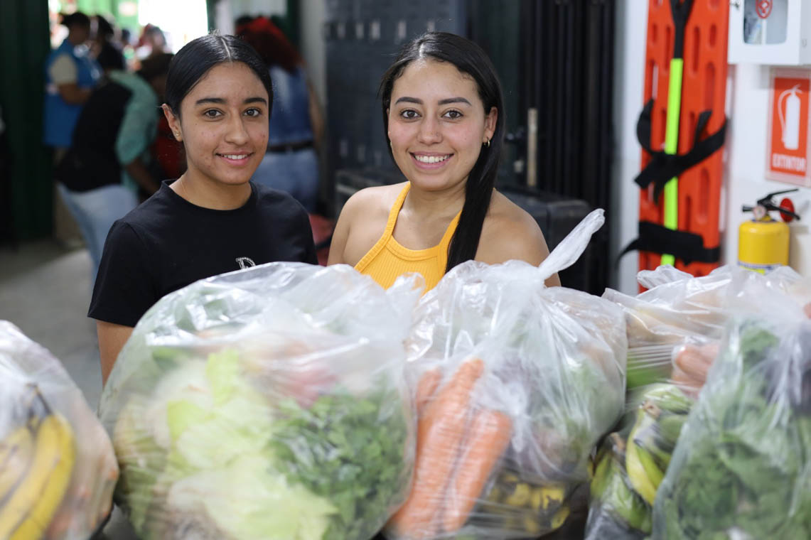 Imagen de dos jovencitas con paquetes de alimentos