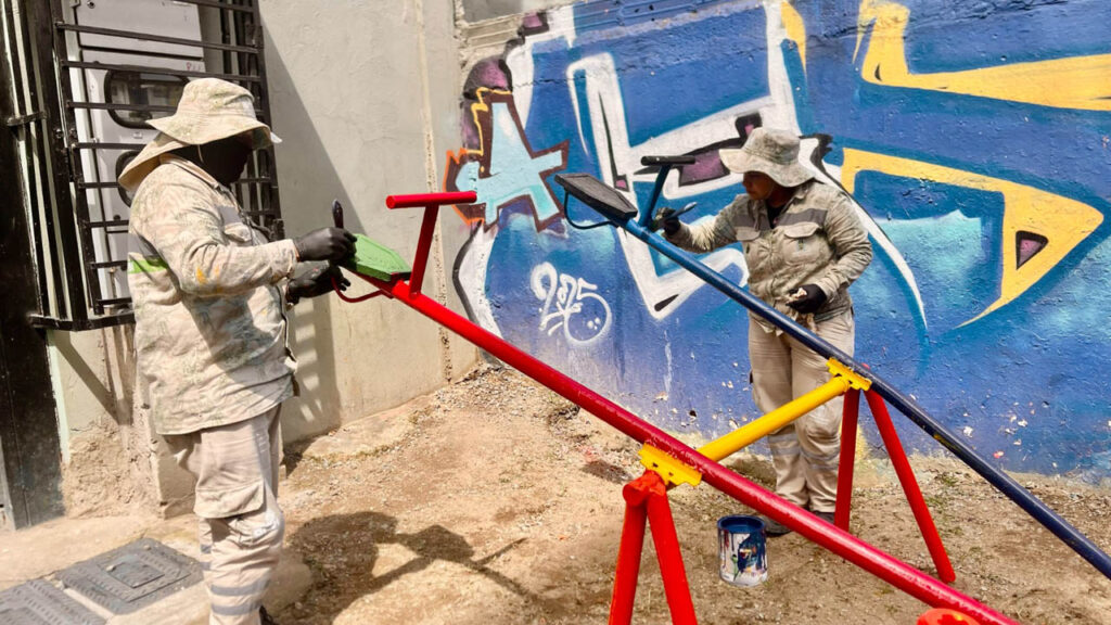 Imagen de obreros pintando un juego infantil