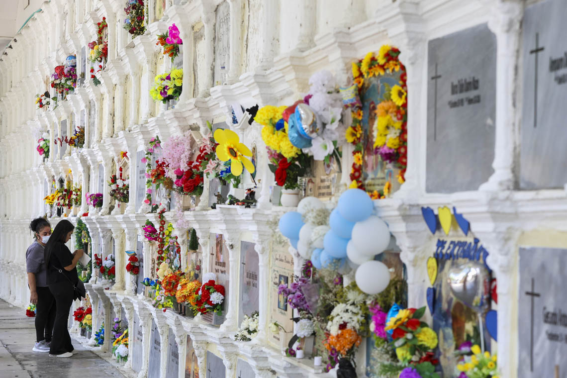 Imagen de dos personas junto a las bóvedas en el Museo Cementerio San Pedro