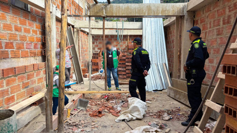 Imagen de policías y funcionarios en una construcción