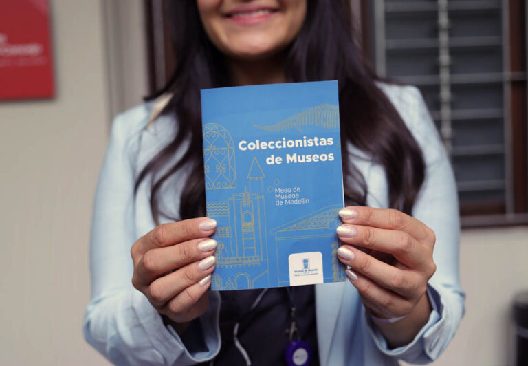 Imagen de una joven mostrando un libro azul